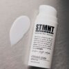 STMNT Aftershave Lotion voor een verzorgde huid, 100ml fles op grijze achtergrond.